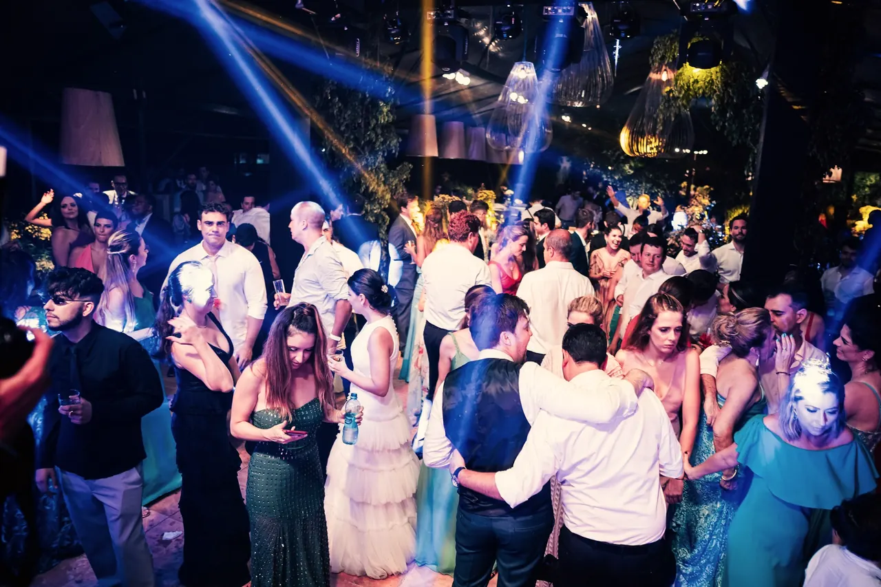 Pista llena de invitados en una fiesta de gala con focos azules
