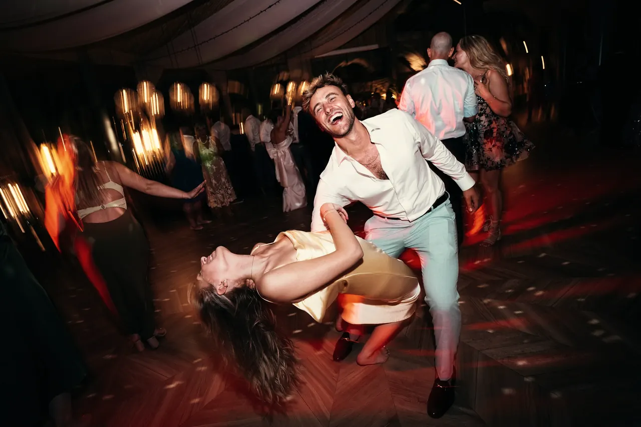 Pareja de invitados bailando en la pista de una boda