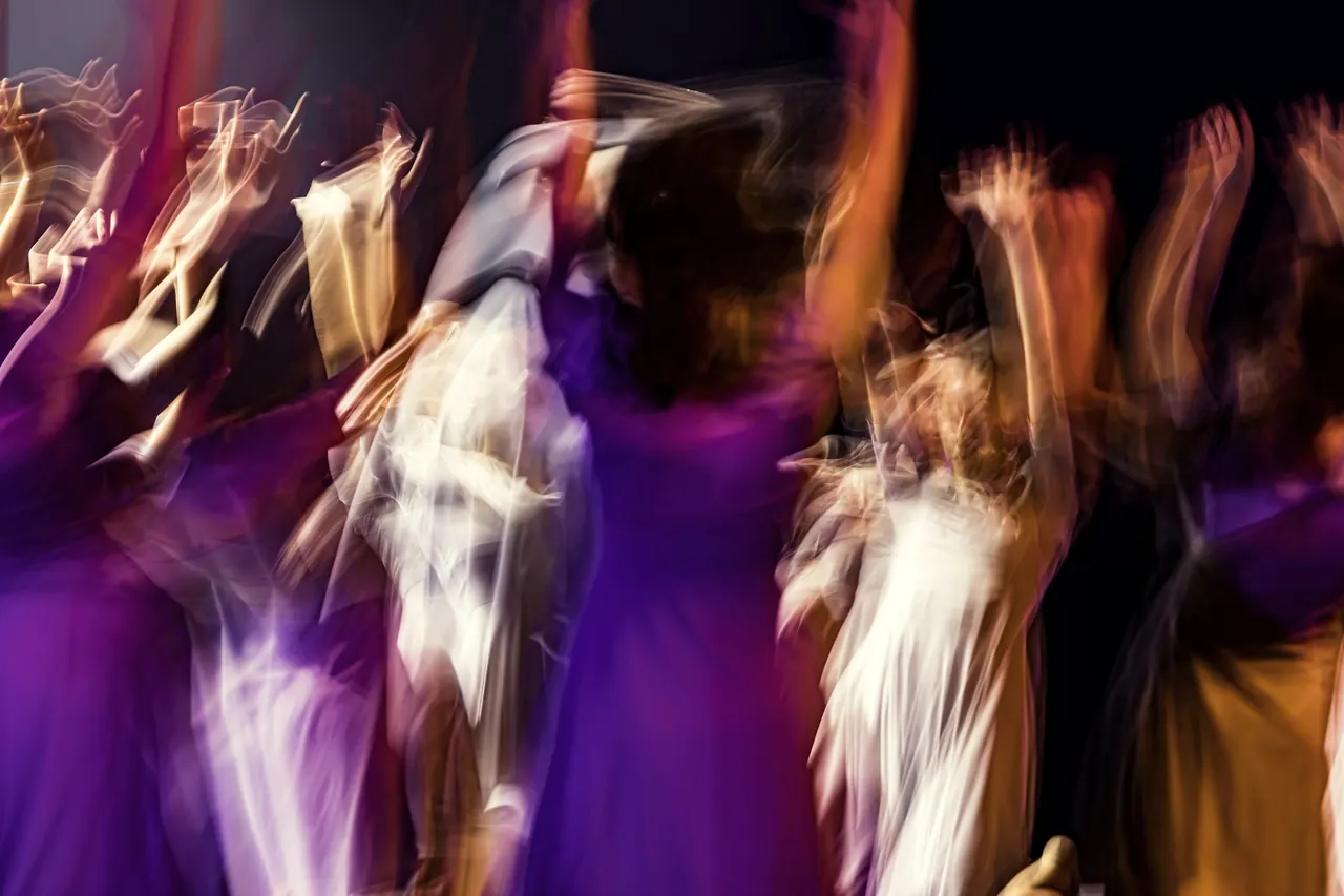 Gente bailando en una fiesta con luces violetas